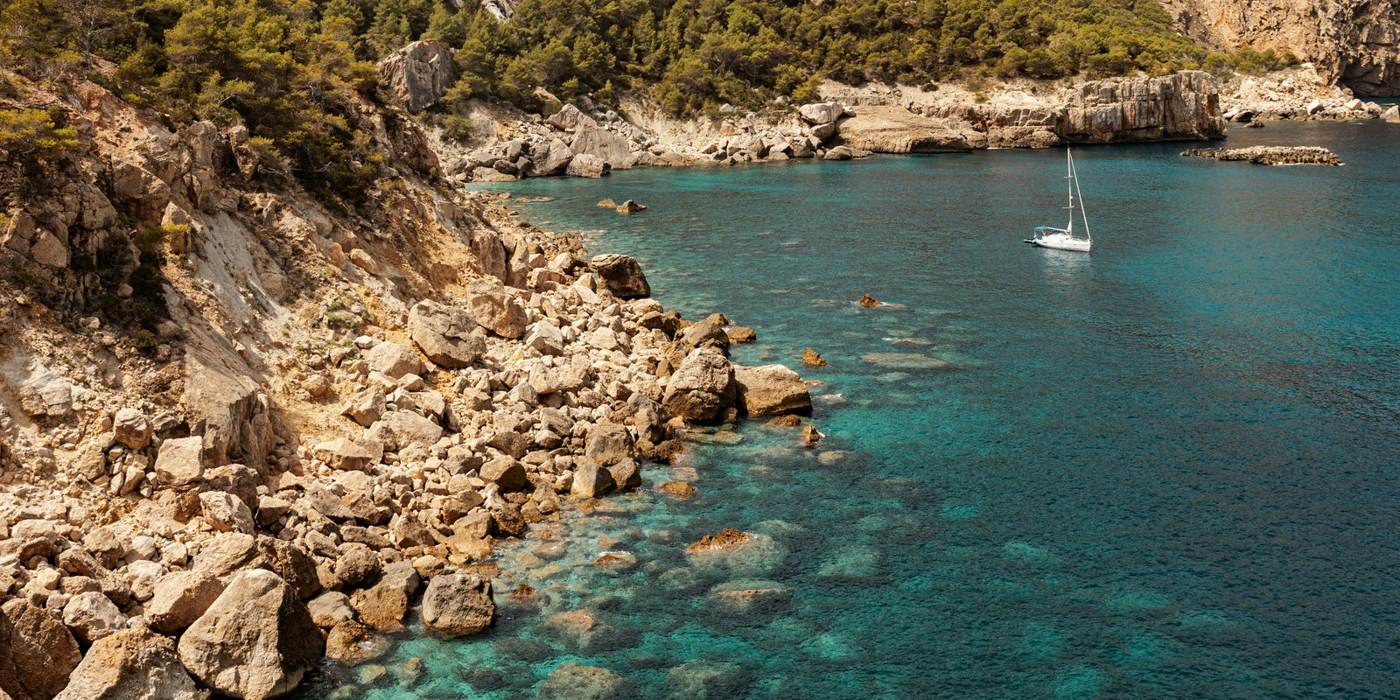 Crique d'Ibiza aux eaux turquoise, entourée de pins