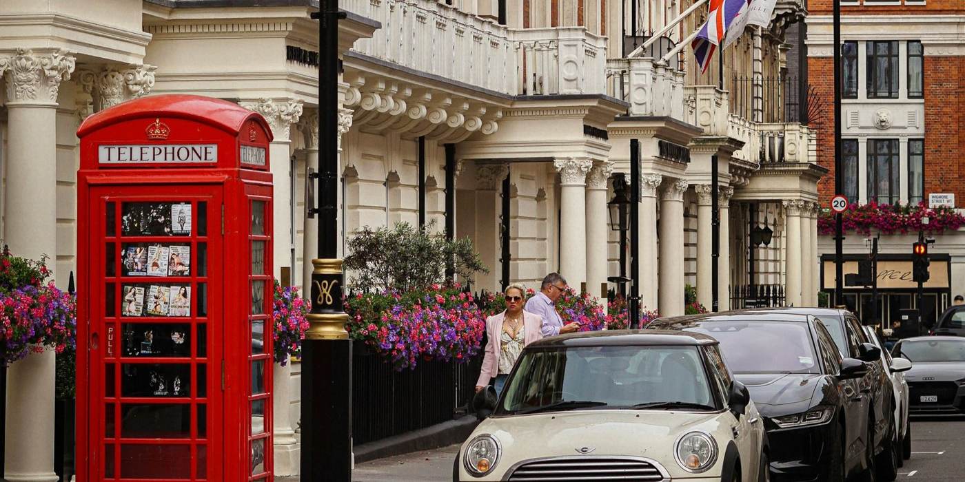 A Mayfair street in London, red telephone box and flower-lined Victorian facades